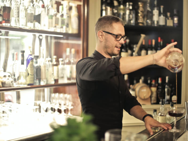 Man pouring spirits into a cocktail glass